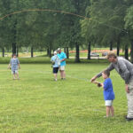 Mike helps this young man make just the right adjustment to his casting stroke.